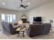 Inviting living room with a cozy fireplace, ceiling fan, neutral walls, and comfortable leather seating at 1421 W Rylie Ct, Queen Creek, AZ 85144