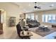 Relaxing living room with plush seating, fan and an open layout connecting to a dining area and kitchen at 1421 W Rylie Ct, Queen Creek, AZ 85144