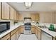 Functional kitchen featuring white countertops, stainless steel appliances and wood cabinets at 14300 W Bell Rd # 145, Surprise, AZ 85374