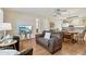 Comfortable living room featuring wood floors, ceiling fan and views into the kitchen and dining area at 14300 W Bell Rd # 145, Surprise, AZ 85374