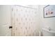 Bright bathroom with floral shower curtain, white toilet, and tasteful wall art at 14637 W Wethersfield Rd, Surprise, AZ 85379