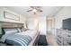 Bright bedroom with an oversized bed, dresser, nightstand, and ceiling fan at 14637 W Wethersfield Rd, Surprise, AZ 85379