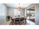 Sunlit dining room featuring a wooden table, seating for six, and sliding glass doors at 14637 W Wethersfield Rd, Surprise, AZ 85379