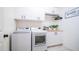 A well-organized laundry room featuring modern white washer and dryer at 14637 W Wethersfield Rd, Surprise, AZ 85379