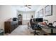 A home office with ample desk space, organized shelving, and a ceiling fan at 14637 W Wethersfield Rd, Surprise, AZ 85379