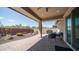 A shaded outdoor patio with a grill, table, seating, and landscaped yard at 14637 W Wethersfield Rd, Surprise, AZ 85379