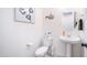 A bright powder room featuring pedestal sink, soft lighting, and decor at 14637 W Wethersfield Rd, Surprise, AZ 85379