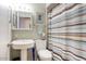 Traditional bathroom featuring a pedestal sink, medicine cabinet, and striped shower curtain at 15601 N 27Th St # 37, Phoenix, AZ 85032