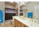Bathroom featuring a dual sink vanity, decorative accents, and a shower-tub combination with modern fixtures at 16112 W Whitton Ave, Goodyear, AZ 85395