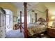 Well-lit bedroom with a luxurious four-poster bed, neutral walls, and plush carpeting at 16112 W Whitton Ave, Goodyear, AZ 85395