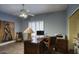 Inviting home office featuring natural light, wood floors, ceiling fan, and stylish desk with matching chair at 16112 W Whitton Ave, Goodyear, AZ 85395