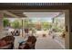 Covered patio featuring comfortable seating, decorative accents, and views of the landscaped backyard at 16112 W Whitton Ave, Goodyear, AZ 85395