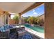 Covered patio with seating area overlooking a freeform swimming pool and landscaping at 17152 W Watkins St, Goodyear, AZ 85338