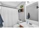 Cozy bathroom featuring a shower with curtain, a white sink, and decorative wall shelving at 17152 W Watkins St, Goodyear, AZ 85338