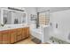 Bright bathroom featuring double sinks, shower with glass door, and soaking tub at 17152 W Watkins St, Goodyear, AZ 85338