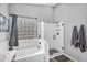 Bright bathroom featuring shower with glass door, soaking tub, and tiled accents at 17152 W Watkins St, Goodyear, AZ 85338