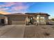 Charming home exterior with a two-car garage, low maintenance desert landscaping, and a welcoming front entrance at 17152 W Watkins St, Goodyear, AZ 85338