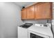 Bright laundry room featuring modern washer and dryer units and ample overhead cabinetry at 17152 W Watkins St, Goodyear, AZ 85338