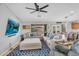 Cozy living room featuring a plush sectional sofa, ceiling fan, and large screen TV at 17152 W Watkins St, Goodyear, AZ 85338