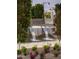 Modern water feature with cascading water surrounded by trees and blooming flowers at 17160 W Montpelier St, Surprise, AZ 85388