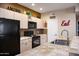 Functional kitchen featuring black appliances, light cabinets, and neutral countertops with decorative accents at 18416 N Cave Creek Rd # 3050, Phoenix, AZ 85032