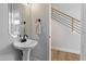 Bathroom featuring a pedestal sink with matte black hardware, modern mirror and fixtures at 19203 N 39Th Way, Phoenix, AZ 85050