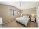Cozy bedroom with a ceiling fan, neutral walls, carpet, and a window overlooking the backyard at 19203 N 39Th Way, Phoenix, AZ 85050