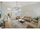 Bright living area has wood floors, white walls, an ornate chandelier, and lots of natural light at 19203 N 39Th Way, Phoenix, AZ 85050
