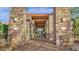 Stone entryway to a commercial building with glass doors, stone columns, and desert landscaping at 19777 N 76Th St # 3229, Scottsdale, AZ 85255