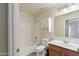 Well-lit bathroom featuring a tub and shower combination, sink, toilet and storage at 206 N 152Nd Ave, Goodyear, AZ 85338