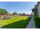 Large backyard with green lawn, play equipment, and an outdoor kitchen at 21341 S 227Th Way, Queen Creek, AZ 85142