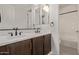 Bright bathroom featuring a dual sink vanity with dark wood cabinets and modern fixtures at 21341 S 227Th Way, Queen Creek, AZ 85142
