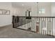 Upstairs hallway with carpet, iron railing, and stylish light fixture at 21341 S 227Th Way, Queen Creek, AZ 85142