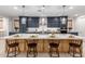 A stylish kitchen features a large island with seating and pendant lighting at 21341 S 227Th Way, Queen Creek, AZ 85142