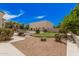 This backyard boasts an in-ground pool, green, desert landscaping, and a multi-purpose outbuilding at 21615 E Pegasus Pkwy, Queen Creek, AZ 85142