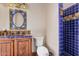 Bathroom with a blue tiled shower and sunflowers painted on the frame of the mirror at 21615 E Pegasus Pkwy, Queen Creek, AZ 85142