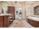 Spacious bathroom with tub, dual sinks, vanity and walk-in closet with custom shelving at 21615 E Pegasus Pkwy, Queen Creek, AZ 85142