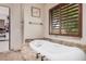 Elegant bathroom featuring a standalone tub with dark wood trim and granite countertops at 21615 E Pegasus Pkwy, Queen Creek, AZ 85142