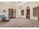 Bedroom with a ceiling fan, rocking chair, and wood-trimmed window and door frames at 21615 E Pegasus Pkwy, Queen Creek, AZ 85142