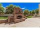 A brick fireplace and wood storage add charm to the backyard space at 21615 E Pegasus Pkwy, Queen Creek, AZ 85142