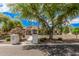 Charming front exterior framed by mature trees, a lush lawn, and beautiful desert landscaping at 21615 E Pegasus Pkwy, Queen Creek, AZ 85142
