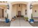 Inviting front porch adorned with potted plants and stylish sconces for a warm welcome at 21615 E Pegasus Pkwy, Queen Creek, AZ 85142