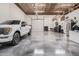 Spacious garage with high ceilings, a car lift, ample storage, and a truck parked inside at 21615 E Pegasus Pkwy, Queen Creek, AZ 85142
