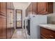 Bright laundry room featuring dual washer/dryer and custom built-in cabinets at 21615 E Pegasus Pkwy, Queen Creek, AZ 85142