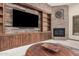 Cozy living room boasts a fireplace, built-in cabinets, and a large screen television at 21615 E Pegasus Pkwy, Queen Creek, AZ 85142