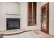 Comfortable living room featuring a cozy fireplace and wooden shuttered windows at 21615 E Pegasus Pkwy, Queen Creek, AZ 85142