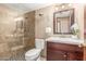 Well-lit bathroom with a walk-in shower with stone and a dark wood vanity cabinet at 2239 S Cottonwood --, Mesa, AZ 85202