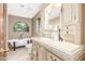 Bright bathroom with decorative cabinets, white fixtures, and an arched window above the bathtub at 2239 S Cottonwood --, Mesa, AZ 85202