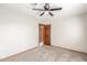 Neutral bedroom showcasing carpet, a ceiling fan, and a stained, solid door to another room at 2239 S Cottonwood --, Mesa, AZ 85202