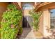 Inviting entryway with decorative iron gate, blooming bougainvillea, and lush landscaping at 2239 S Cottonwood --, Mesa, AZ 85202